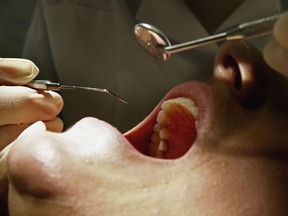 A patient undergoes a dental examination to detect tooth decay or gum disease that could have other impacts on general health.