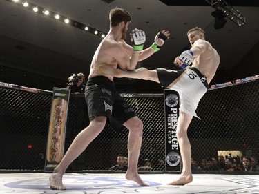 Mariusz Ksiazkiewicz, right, slams his foot into the torso of Micah Brakefield during the Queen City Coronation, an MMA event held at the Orr Centre in Regina on Saturday March 12, 2016.