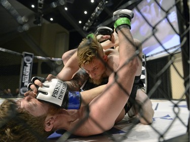 Mariusz Ksiazkiewicz, top, grapples with Micah Brakefield during the Queen City Coronation, an MMA event held at the Orr Centre in Regina on Saturday March 12, 2016.