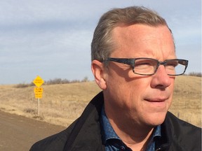 Brad Wall stands on Highway 322, near Silton Sask., for an election promise to up highways funding.