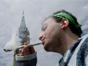 A man is shown smoking a joint at the Fill the Hill marijuana rally on Parliament Hill in Ottawa on April 20, 2014.