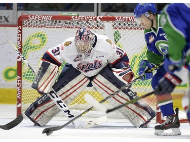 Regina Pats goalie Tyler Brown keeps an eye on the puck as Swift Currents Broncos Jon Martin has the puck on his stick in first period WHL action at the Brandt Centre in Regina on Friday.