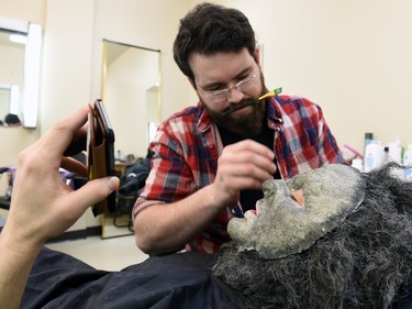 Leo Fafard talks on his mobile in the midst of his 2-hour makeup transformation into WolfCop by make-up artist Emersen Ziffle at the Soundstage in Regina.