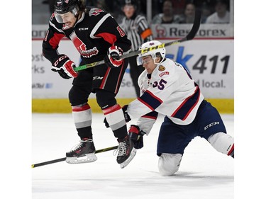 Liam Schioler (R) with the Regina Pats and Jesse Shynkaruk (L) with the Moose Jaw Warriors battle for the puck during WHL hockey action at the Brandt Centre in Regina on March 11, 2016.