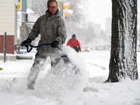 Ryan Hillstead shovels snow on the 500 block of Victoria Avenue after overnight snowfall on March 22, 2016.