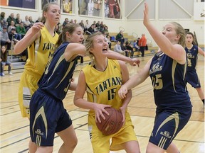The Winston Knoll Wolverines' Mackenzie Moore, left, and Cassandra Ford, right, cover the Campbell Tartans' Madyson Hautz, shown with the basketball, in Thursday's Regina Intercollegiate Basketball League junior girls large schools final at Luther College High School's Semple Gymnasium.