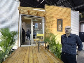 John Robinson, partner and principal designer of Robinson Residential, stands in front of the company's first "tiny house."