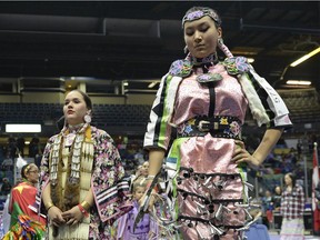 Dance instructor Jayda Delorme, left, and Mia Chartrand, right, participate in an initiation dance at the FNUC Pow-wow held at the Brandt Centre in Regina on Saturday.