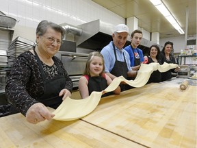 Lucia Barone (left), Mica Frei, Joe Parisone, Joe Pierno, Anna Barone, and Anna Carteri hold a long piece of pasta in the kitchen at the Italian Club kitchen in Regina. The family will cook for Flavours of Italy, an event to debut on April 23 to promote Italian culture and traditions and to raise money for the Regina Open Door Society.