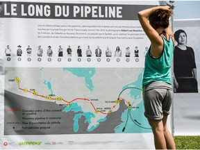 Melissa Lachance of Montreal, looks at a map of the proposed Energy East pipeline, at a rally organized by Greenpeace and other groups in Hudson, Quebec, on July 4, 2015.