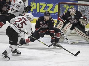 Adam Musil of the Red Deer Rebels, 25, takes a shot as Regina Pats captain Colby Williams defends in front of goaltender Tyler Brown during second-period WHL playoff action on Tuesday at the Enmax Centrium. Red Deer posted a 2-1 victory to win Game 7 of a WHL Eastern Conference semifinal.