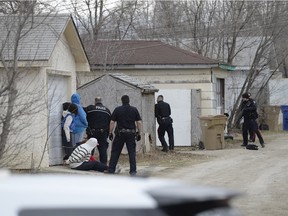 Regina Police Service members take position around a house in the 800 block of Garnet St. in Regina on Saturday April 9, 2016.