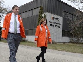 Clad in orange protective gear, Regina-Qu'Appelle MP Andrew Scheer (left) and the  interim leader of the Conservative Party of Canada, Rona Ambrose, walk toward a media scrum after touring the EVRAZ steel works in Regina, Sask. on Tuesday.