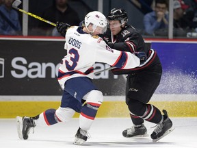 The Regina Pats' Riley Woods, left, and Red Deer Rebels' Nelson Nogier get tied up away from a loose puck in WHL playoff action at the Brandt Centre on Tuesday — when the Pats' fans were part of the story as the home team won 6-3.