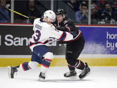 Regina Pats Riley Woods, left, and Red Deer Rebels Nelson Nosier get tied up away from the loose puck in WHL playoff action at the Brandt Centre in Regina on Tuesday.