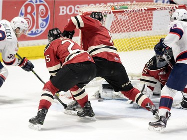 Regina Pats Lane Zablocki #31, left, puts the loose puck past  Red Deer Rebels goalie Trevor Martin #35 in first period WHL playoff action at the Brandt Centre in Regina on Wednesday.