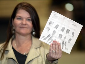 Kerri-Lynn Alfonso of Stoughton, SK, holds up her finger prints as part of her police background check in Regina on Friday.