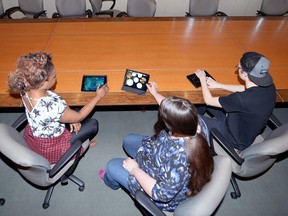 Victoria Ordu (left), Rebecca Caines and Logan Froese jam with their iPads on Friday in the University of Regina boardroom.