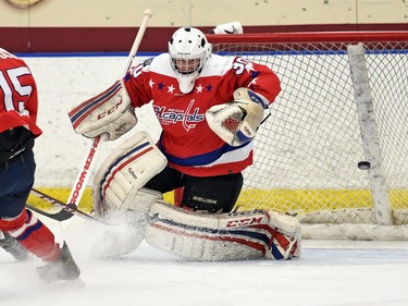 Tyler Povelofskie (L) with the 100 Mile House Wranglers scores on netminder Carson Bodgan with the Extreme Hockey Regina Capitals during a game at the Keystone Cup at the Co-operators Centre in Regina.