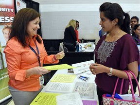 Alisa Scherle (L) with Great West Life talks with Glory Paul (R) from India during the the Regina Open Door Society's first annual job fair held at the Core Ritchie Centre in Regina on April 28, 2016.