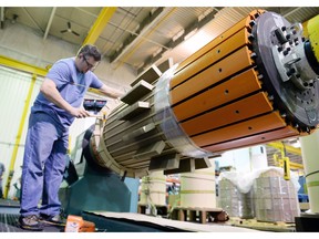 An employee  at Partner Technologies Inc. in Regina works on a transformer coil in this file photo.  Manufacturing sales were down eight per cent to $1.12 billion in February from $1.2 billion in January, Statistics Canada said Friday.