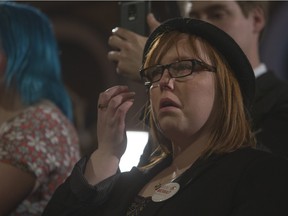 A tearful NDP supporter listens as various candidates speak at the party's election headquarters in Saskatoon on election night.