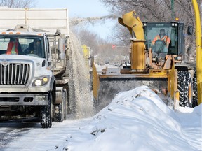 City crews move snow piles made by snow clearing on the 900 block of Dorothy Street.