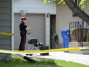 A Regina police officer stands at a crime scene.