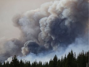 Flames rise off Highway 63 outside Fort McMurray. The fire increased in size to over 1,600 square kilometres over the weekend.