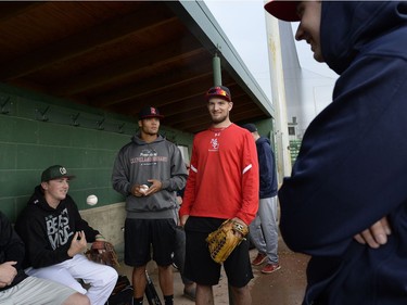 Chase Nistor, Jonathan Nunnally, Jordan Schulz, from left, wait in the dugout for the rain to let up during a Regina Red Sox training camp at Currie Field in Regina, Sask. on Monday May. 23, 2016.