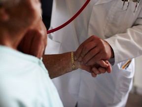 Doctor holds patient's hand.