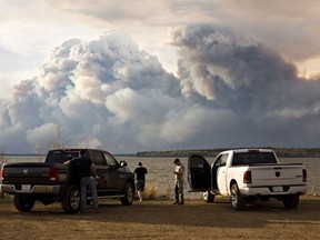 Evacuees watch the wildfire near Fort McMurray, Alberta, on Wednesday, May 4, 2016. Alberta declared a state of emergency Wednesday as crews frantically held back wind-whipped wildfires.  No injuries or fatalities have been reported.