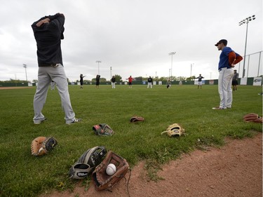 Gloves lays to the side while players stretch at a Regina Red Sox training camp at Currie Field in Regina, Sask. on Monday May. 23, 2016.