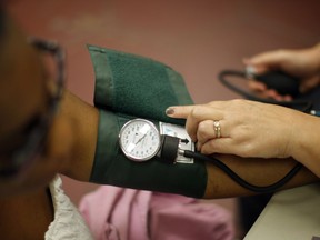 A nurse checks the blood pressure of a patient.
