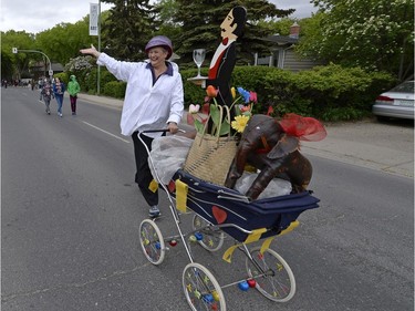 Maria Hendrika pushes an art cart that includes a butler, an elephant and flowers in the Cathedral Village Arts Festival kickoff parade on May 23, 2016.