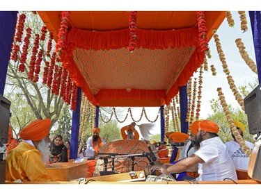 Musicians on a raised platform accompany the Guru Granth Sahib (Holy Book).