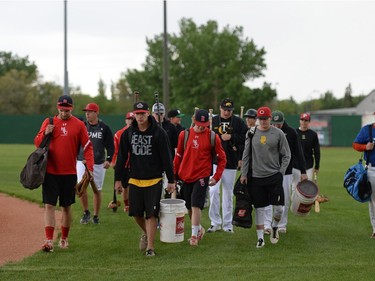 Players carry equipment to the dugout at the start of a Regina Red Sox training camp at Currie Field in Regina, Sask. on Monday May. 23, 2016.
