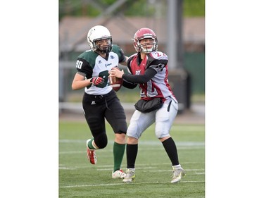 Regina Riot quarter back Aimee Kowalski (22) about to be sacked by Saskatoon Valkyries defensive lineman Betsy Mawdsley (90) at Mosaic Stadium in Regina, Sask. on Saturday May. 28, 2016.