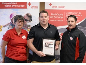 Rebecca Benko, left, Sask. operations manager Red Cross, and Scott Osmachenko, right, president of the Sask. provincial advisory committee, award Shaun Silzer the Red Cross Rescuer Award  in Regina on Wednesday.  The award was of the Saskatchewan and Manitoba Water Safety Conference held at the Travelodge Hotel.