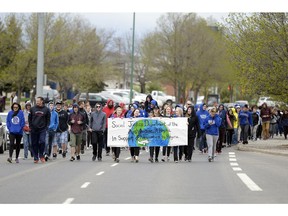 Riffel High School students walk down Rochdale Blvd. during their 20th annual wellness day charity classic in Regina on Thursday.  Students raises money to support Regina's newcomers.