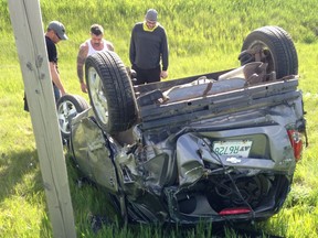 REGINA, SASK May 29, 2016 - Andrew Quigley (white shirt) and Ryan Pope (yellow hoodie, grey shirt) look at the wreckage of a vehicle following a rollover outside of Regina. SUBMITTED PHOTO