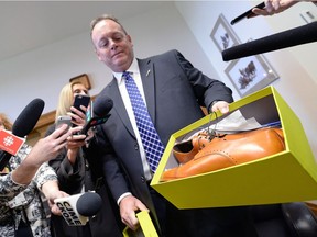 Finance Minister Kevin Doherty takes part in the annual "shoes" pre-budget photo Tuesday. Doherty's new brown shoes, representing "transformational change," were tight.