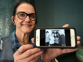 Cecile Matysio shows a photo of herself and her children on her smartphone.