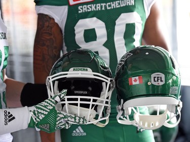 Matt Webster and Spencer Moore show off the new helmets at the launch of the new Saskatchewan Roughriders adidas uniforms for the 2016 season. The black trim was removed from the jersey and the numbers and the pants feature four stripes on the left side – each one representing a Grey Cup victory over the years.