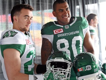 Matt Webster and Spencer Moore show off the new helmets at the launch of the new Saskatchewan Roughriders adidas uniforms for the 2016 season. The black trim was removed from the jersey and the numbers and the pants feature four stripes on the left side – each one representing a Grey Cup victory over the years.