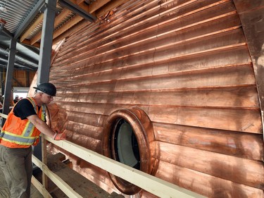 PCL's Mirus Burrasch beside a dormer window during the  Saskatchewan Legislature Dome Renewal. The project has used 12,700 kilograms of copper, worth $100,000 while the entire restoration project cost is approximately $21 million.