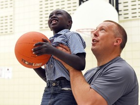 REGINA SK: MAY 19, 2016 –  Gene Makowsky , Saskatchewan MLA for Regina Gardiner Park with Achien Achin participating in the  Buddies program's first ever "Hooping it up" free throw competition at St. Marguerite Bougeoys School in Regina. The program itself helps to foster special friendships between students with special needs and their typical peers.   DON HEALY