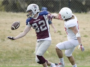 Regina Thunder receiver Lee Brown, 82, manages to make a reception while Saint John's University Johnnies defensive back Leonard Gutierrez, 27, covers him at Leibel Field on Saturday.