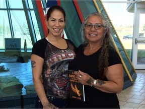 Sharon Acoose (right) poses with her daughter Starla Littletent and a copy of her new book, A Fire Burns Within: Teachings from Ceremony and Culture, at First Nations University in Regina on Tuesday.