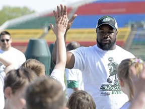 Saskatchewan Roughriders defensive end Shawn Lemon shares a high-five during the Don Narcisse All-Star Football Camp on Saturday at Mosaic Stadium.